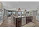 Open kitchen featuring an island, hardwood floors, and seamless integration with the dining and living areas for easy entertaining at 11796 Edenfeld St, Parker, CO 80134