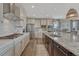 Bright kitchen with an island, stainless steel appliances, modern lighting and white cabinets at 11796 Edenfeld St, Parker, CO 80134