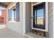 Front entry with black door and welcome mat at 488 Vista Blvd, Brighton, CO 80603