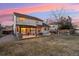 Beautiful backyard with a pergola-covered patio, green lawn, and mature trees at dusk at 9407 Dolton Way, Highlands Ranch, CO 80126