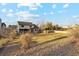 Wide angle of an expansive backyard with a lush lawn, stone patio, pergola and neutral-toned house at 9407 Dolton Way, Highlands Ranch, CO 80126