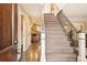 Welcoming entryway with hardwood floors, staircase with iron railings, and a view into the kitchen at 9407 Dolton Way, Highlands Ranch, CO 80126