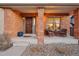 Charming front porch with brick columns, seating area, and a welcoming wooden front door at 9407 Dolton Way, Highlands Ranch, CO 80126