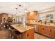 Kitchen island with bar seating connects to the living room with brick fireplace at 9407 Dolton Way, Highlands Ranch, CO 80126