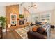 Cozy living room showcasing a brick fireplace, built-in shelving, hardwood floors, and comfortable seating at 9407 Dolton Way, Highlands Ranch, CO 80126