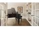 Elegant living room featuring a grand piano, built-in bookshelves, and French doors, perfect for entertaining at 9407 Dolton Way, Highlands Ranch, CO 80126