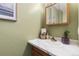 Well-lit bathroom features a vanity with a marble countertop and a framed medicine cabinet at 1457 S Pierce St, Lakewood, CO 80232