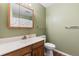 Bathroom featuring a vanity, framed mirror, and a toilet; neutral paint at 1457 S Pierce St, Lakewood, CO 80232