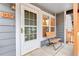 Cozy front porch featuring a bench, white door, and gray siding at 1457 S Pierce St, Lakewood, CO 80232