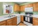 Functional kitchen featuring white countertops, wood cabinets, modern appliances, and ample natural light at 1457 S Pierce St, Lakewood, CO 80232