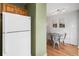 Bright kitchen area with white refrigerator adjacent to a dining space with a unique glass-top table at 1457 S Pierce St, Lakewood, CO 80232