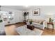 Bright living room with wood-look flooring, light gray sofa, neutral rug, and large window providing natural light at 1457 S Pierce St, Lakewood, CO 80232