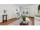 Bright living room featuring wood-look flooring, a neutral rug, and views of the front yard and staircase at 1457 S Pierce St, Lakewood, CO 80232