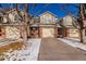 Tan two-story townhome with attached garage and snowy front yard at 15907 E 13Th Ave, Aurora, CO 80011