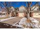 Two-story townhome with attached garage and winter landscaping at 15907 E 13Th Ave, Aurora, CO 80011