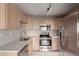 Modern kitchen with stainless steel appliances and light wood cabinets at 15907 E 13Th Ave, Aurora, CO 80011