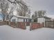 Rear view of the house with snow-covered yard and fence at 1120 N Norfolk St, Aurora, CO 80011