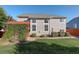 Back of house with big windows, a covered wooden pergola, green lawn, and mature shrubs at 16553 Gilpin St, Thornton, CO 80602