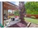 Backyard featuring a wooden pergola, comfortable seating, green lawn, and beautiful landscaping at 16553 Gilpin St, Thornton, CO 80602