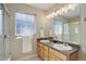 Bright bathroom with double vanity, natural light, and a shower at 16553 Gilpin St, Thornton, CO 80602