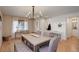 Well-lit dining room with wood floors, modern chandelier, seating for six, and a custom storage unit at 16553 Gilpin St, Thornton, CO 80602