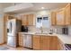 Kitchen features stainless steel appliances, light wood cabinets, light countertops, and a window at 16553 Gilpin St, Thornton, CO 80602