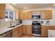 Kitchen features stainless steel appliances, light wood cabinets, light countertops, and tile backsplash at 16553 Gilpin St, Thornton, CO 80602