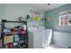 Well-organized laundry room with a washer, dryer, shelving, and natural light for added convenience at 16553 Gilpin St, Thornton, CO 80602