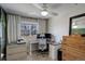 Inviting office with a large window, a ceiling fan, modern desk, and storage options at 16553 Gilpin St, Thornton, CO 80602