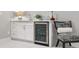 Stylish bar area with white cabinets, beverage refrigerator, and decorative accents at 7155 E Exposition Ave, Denver, CO 80224