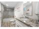 Well-lit bathroom showcasing a granite countertop, modern fixtures, tiled shower, and wood-look flooring at 7155 E Exposition Ave, Denver, CO 80224
