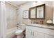Bright bathroom featuring a tub with marble tile surround, granite countertop, and framed butterfly art at 7155 E Exposition Ave, Denver, CO 80224