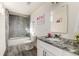 Bathroom with updated vanity with granite countertop and tiled shower with glass door at 7155 E Exposition Ave, Denver, CO 80224