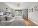 Bright bedroom showcasing hardwood floors, a cozy bed, and large windows with neighborhood views at 7155 E Exposition Ave, Denver, CO 80224