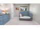 Serene Bedroom featuring a light blue crib, matching dresser, and soft carpet at 7155 E Exposition Ave, Denver, CO 80224