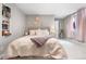 Comfortable bedroom features a cozy bed, bookshelf, and light pink curtains for a relaxing and stylish retreat at 7155 E Exposition Ave, Denver, CO 80224