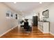 Dining area with hardwood floors and views into the modern kitchen at 7155 E Exposition Ave, Denver, CO 80224