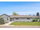 Charming single-story home featuring a well-maintained lawn and a freshly painted gray exterior at 7155 E Exposition Ave, Denver, CO 80224