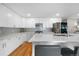 Modern kitchen with stainless steel appliances, white cabinetry, a breakfast bar and sleek countertops at 7155 E Exposition Ave, Denver, CO 80224