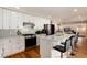 Modern kitchen with white cabinets, quartz countertop, stainless appliances, island and bar seating at 7155 E Exposition Ave, Denver, CO 80224