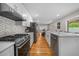 Modern kitchen featuring stainless steel appliances, white cabinetry, sleek countertops, and hardwood floors at 7155 E Exposition Ave, Denver, CO 80224