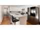 Stylish kitchen with white cabinets, quartz countertops, stainless appliances, and island with bar stool seating at 7155 E Exposition Ave, Denver, CO 80224
