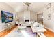 Bright living room with a fireplace, large sectional sofa, a ceiling fan, and wood floors at 7155 E Exposition Ave, Denver, CO 80224