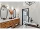 Well-lit bathroom featuring dual vanities, elegant mirrors, and a glass-enclosed shower at 7388 S Ireland Cir, Centennial, CO 80016