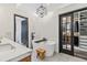Modern bathroom with a freestanding tub, open closet and a sleek, geometric light fixture at 7388 S Ireland Cir, Centennial, CO 80016