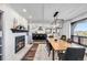 Bright dining room featuring a modern light fixture, brick fireplace, and view into the kitchen at 7388 S Ireland Cir, Centennial, CO 80016