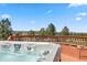 Inviting hot tub on a wooden deck with views of trees and blue sky at 7388 S Ireland Cir, Centennial, CO 80016