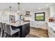 Bright modern kitchen with white cabinets, black island with seating, and stainless steel appliances at 7388 S Ireland Cir, Centennial, CO 80016