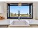 Bright kitchen featuring white countertops, farmhouse sink, subway tile backsplash, and a beautiful view at 7388 S Ireland Cir, Centennial, CO 80016