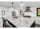 Modern kitchen with large marble island, stainless steel appliances, and sleek finishes at 7388 S Ireland Cir, Centennial, CO 80016